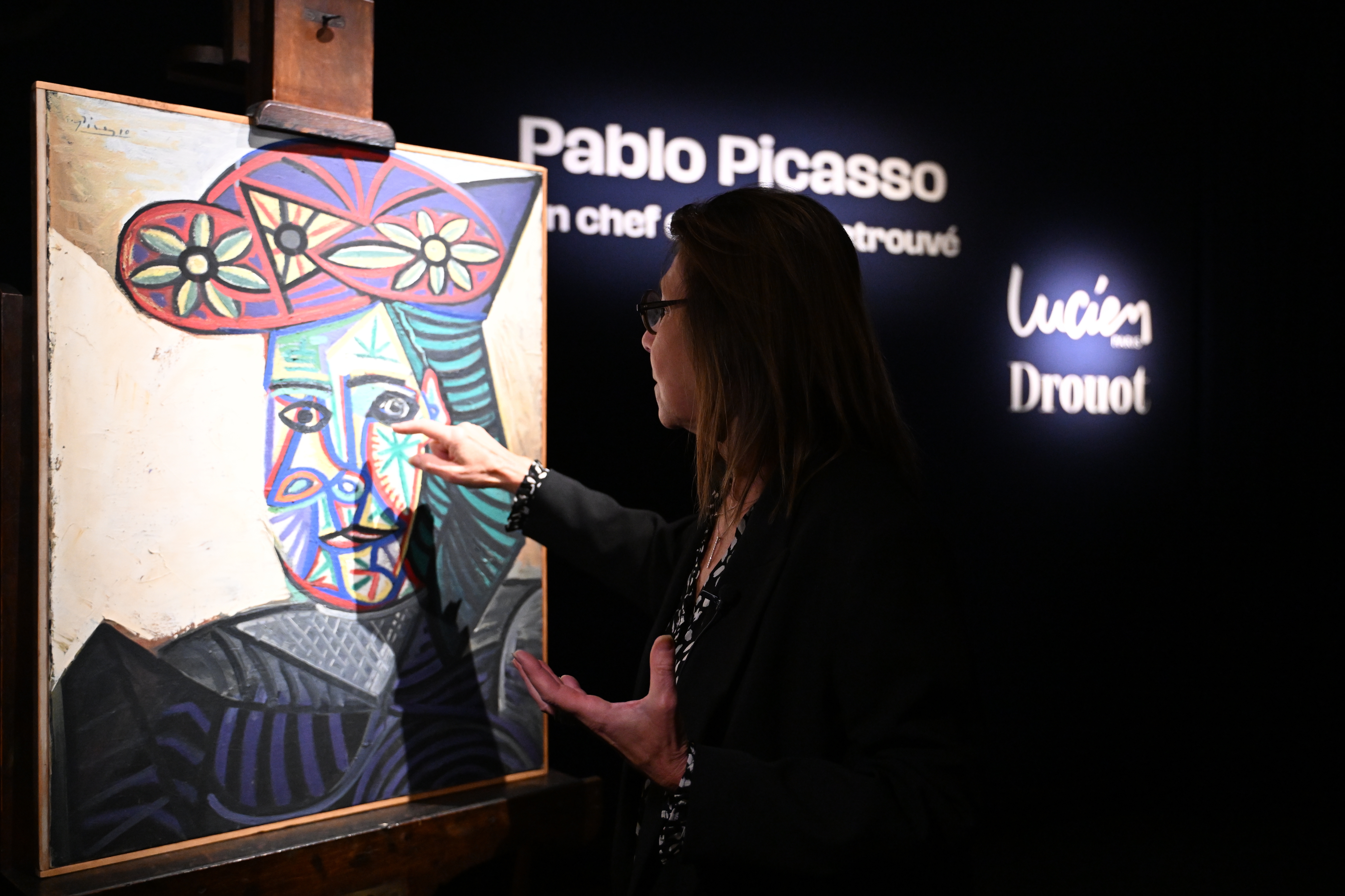 Art expert Agnes Sevestre-Barbe points to a rediscovered Picasso painting "Bust of a Woman in a Flowery Hat," on Wednesday in Paris. The portrait of longtime muse and partner Dora Maar sold Friday at auction for 32 million euros (about $37 million).